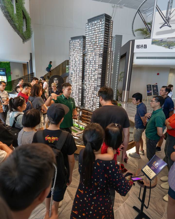 Clients gathered around a scale model at a Kuala Lumpur sales gallery