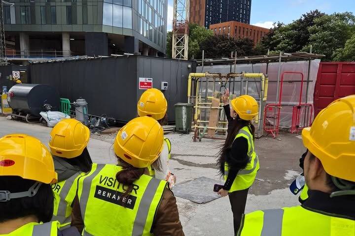 Clients in hard hats on a UK construction site visit