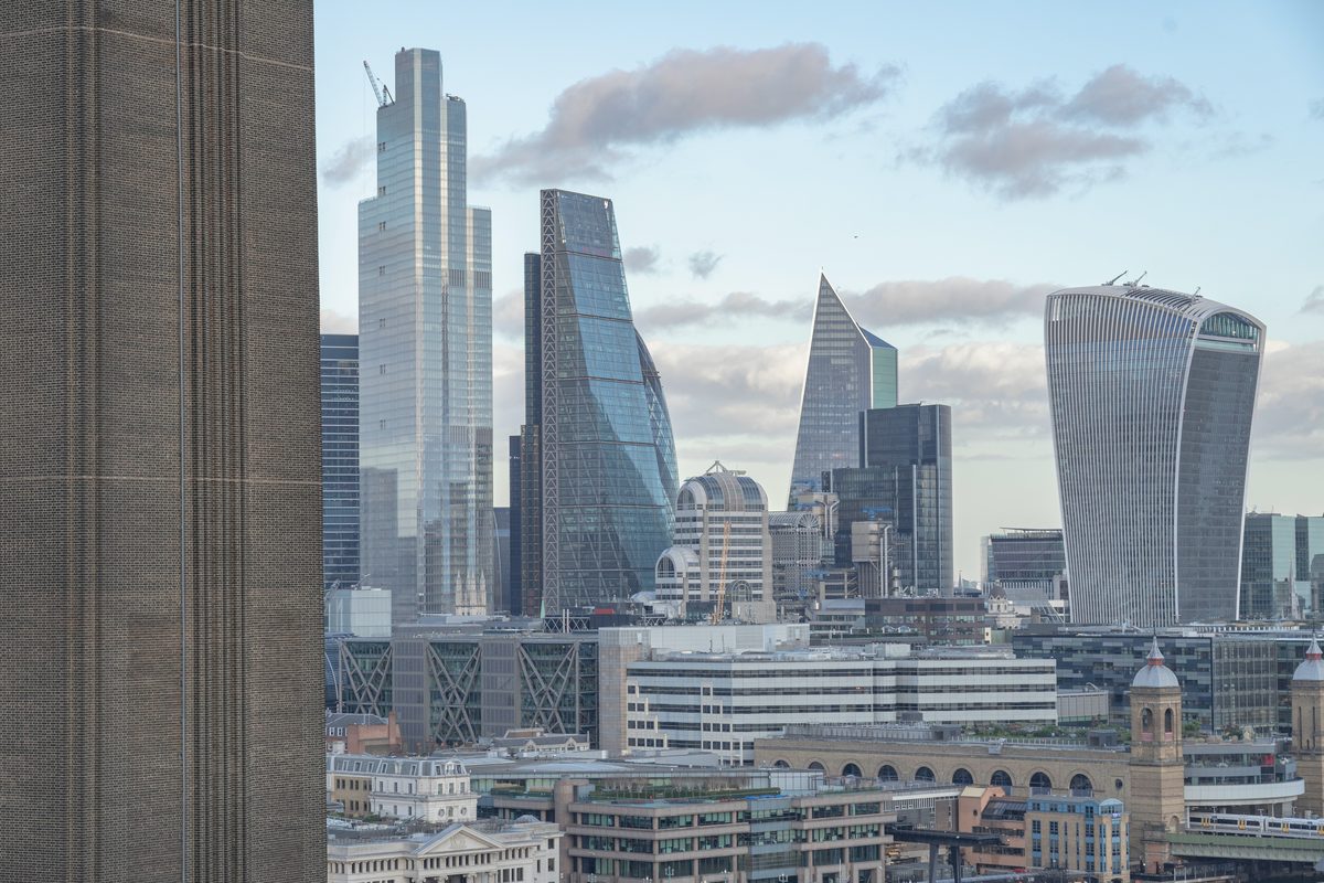 The City of London skyline across the Thames, with construction cranes among the towers